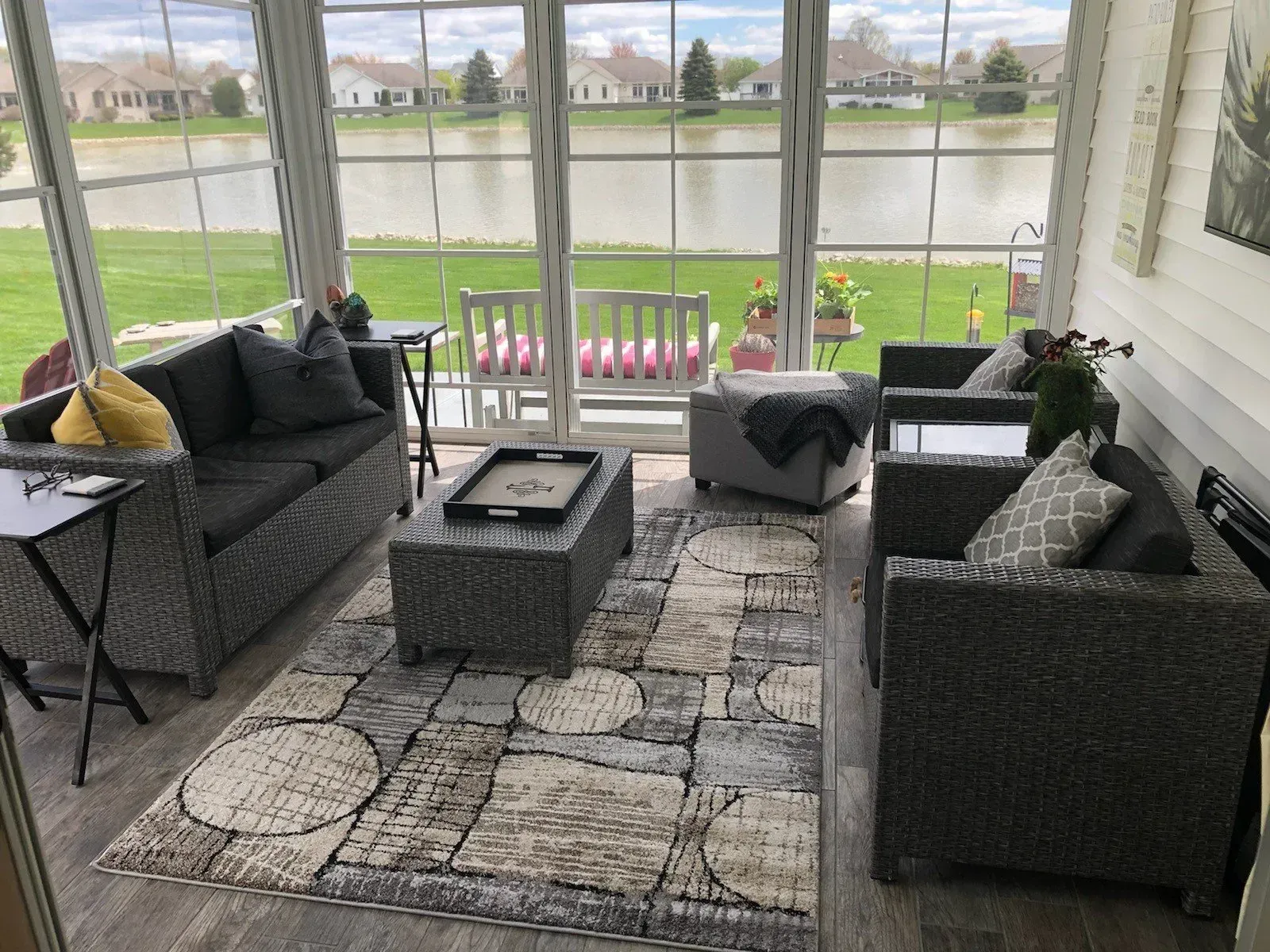 A living room with a couch , chairs , coffee table and rug.