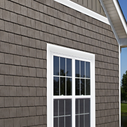 A gray house with a white window on the side