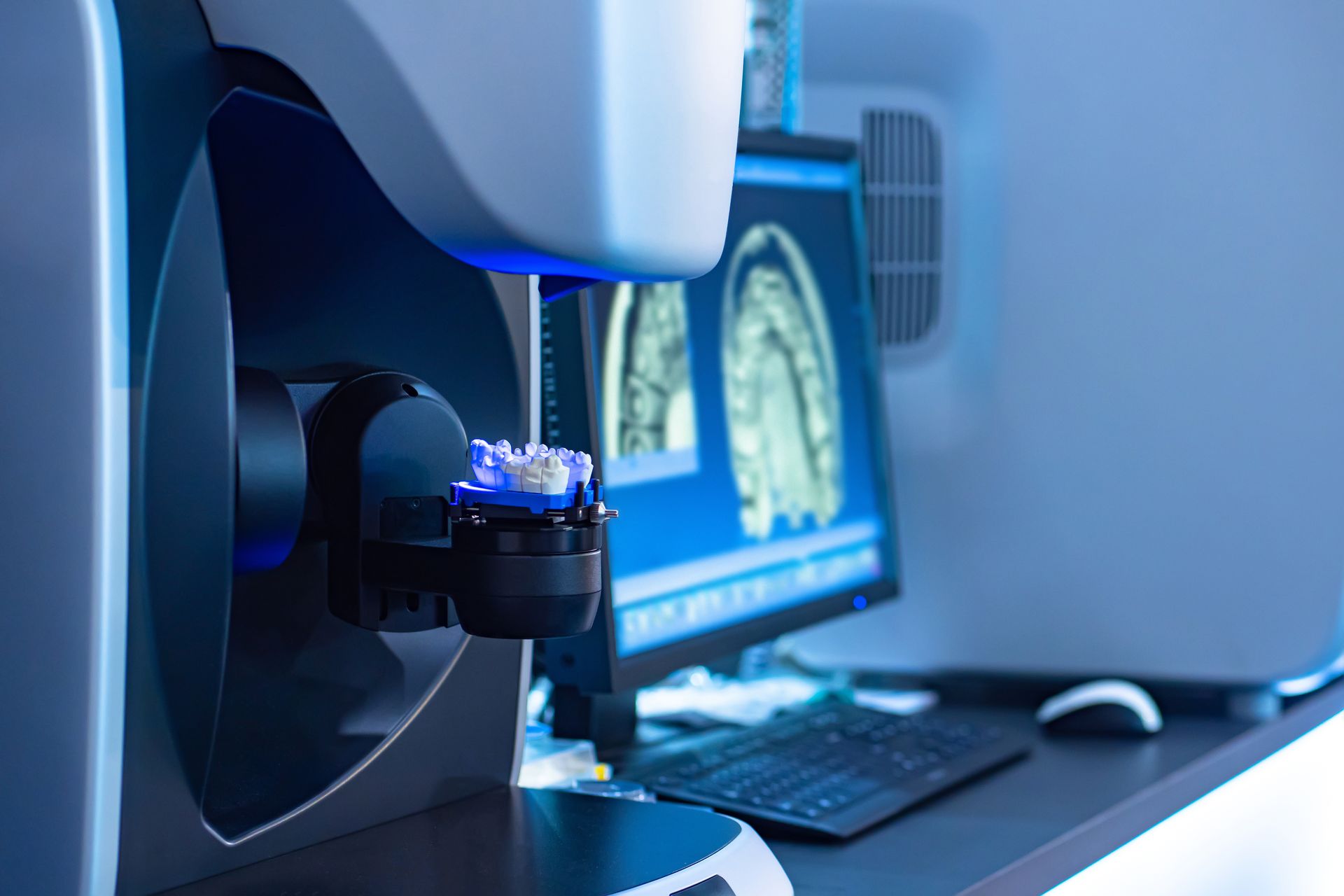 Lab equipment beside a monitor showing a magnified microscopic sample.