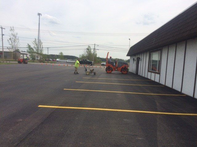 Paving contractor working on a parking lot sealing job in Batavia, NY