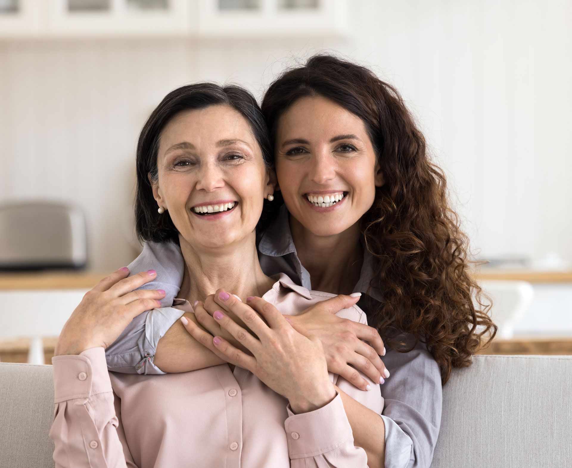 Two women are hugging each other and smiling for the camera.