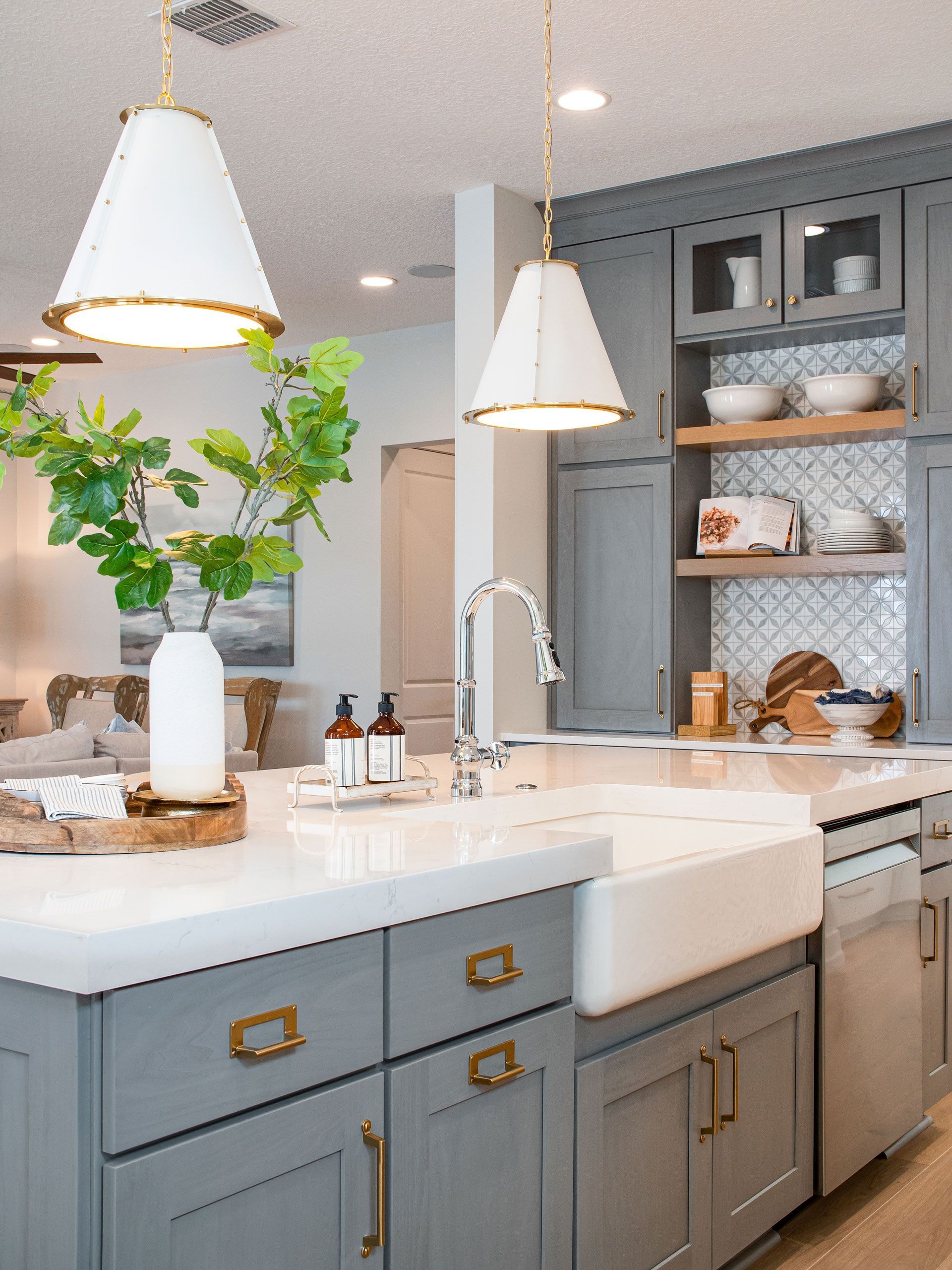 A kitchen with gray cabinets and a white sink.