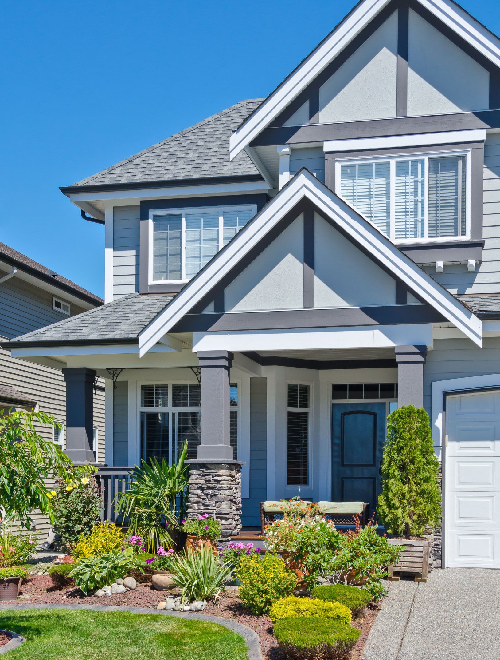 A large house with a lot of windows and a lot of plants in front of it.