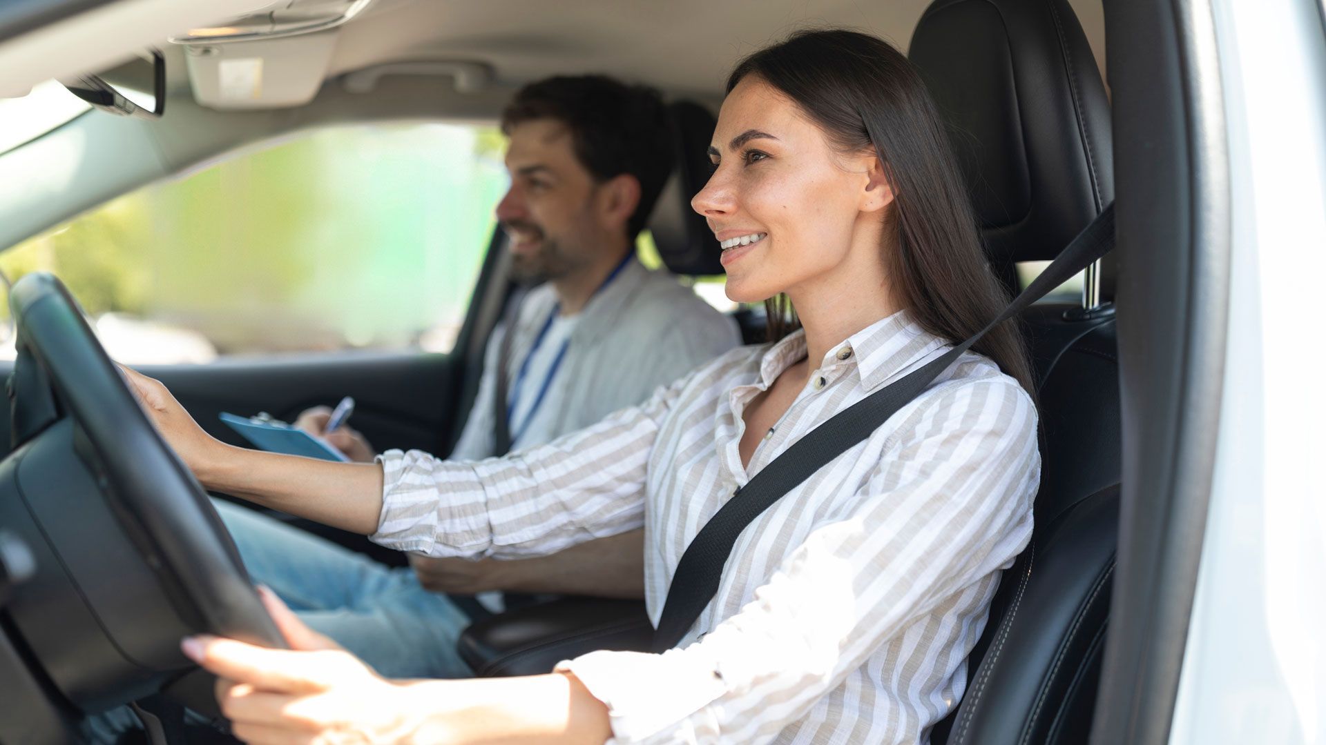 A man is teaching a woman how to drive a car.
