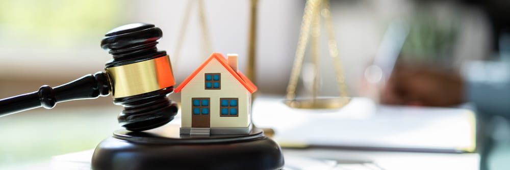 A judge 's gavel with a model of a house on top of it.