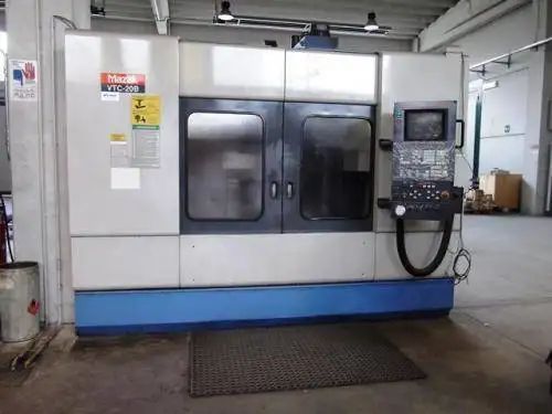 Fresatrice CNC, grigia e blu, in un ambiente da officina.