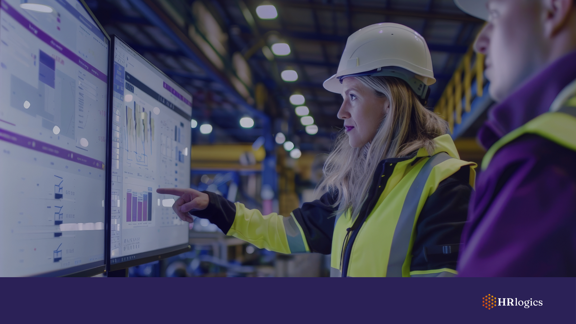 Engineer and operations manager reviewing financial dashboards on a factory touchscreen
