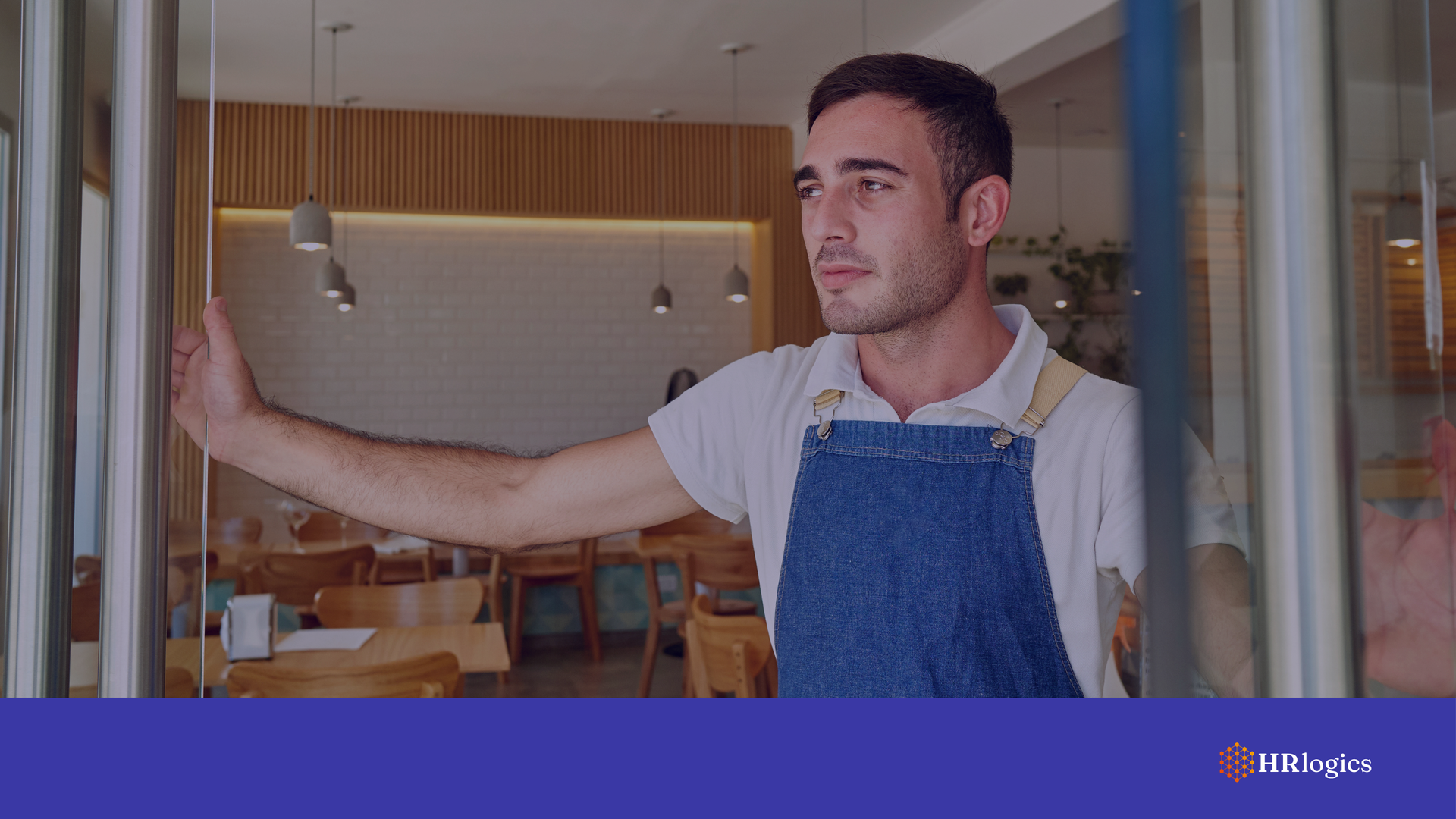 Restaurant owner stands in doorway of an empty dining room—capturing the impact of immigration enforcement on local businesses and workforce stability.