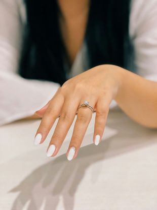 A close up of a woman 's hand with a ring on her finger