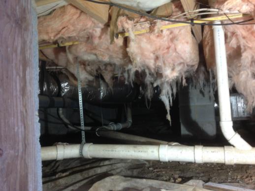 A basement with a lot of pipes and insulation