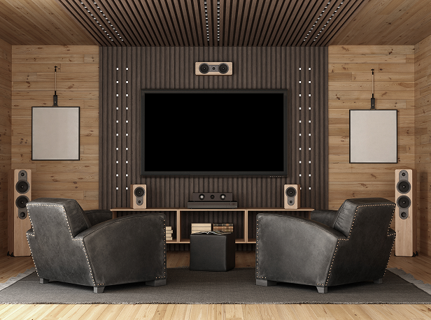 Home theater: TV centered on a wooden wall, flanked by speakers, chairs, and framed artwork.