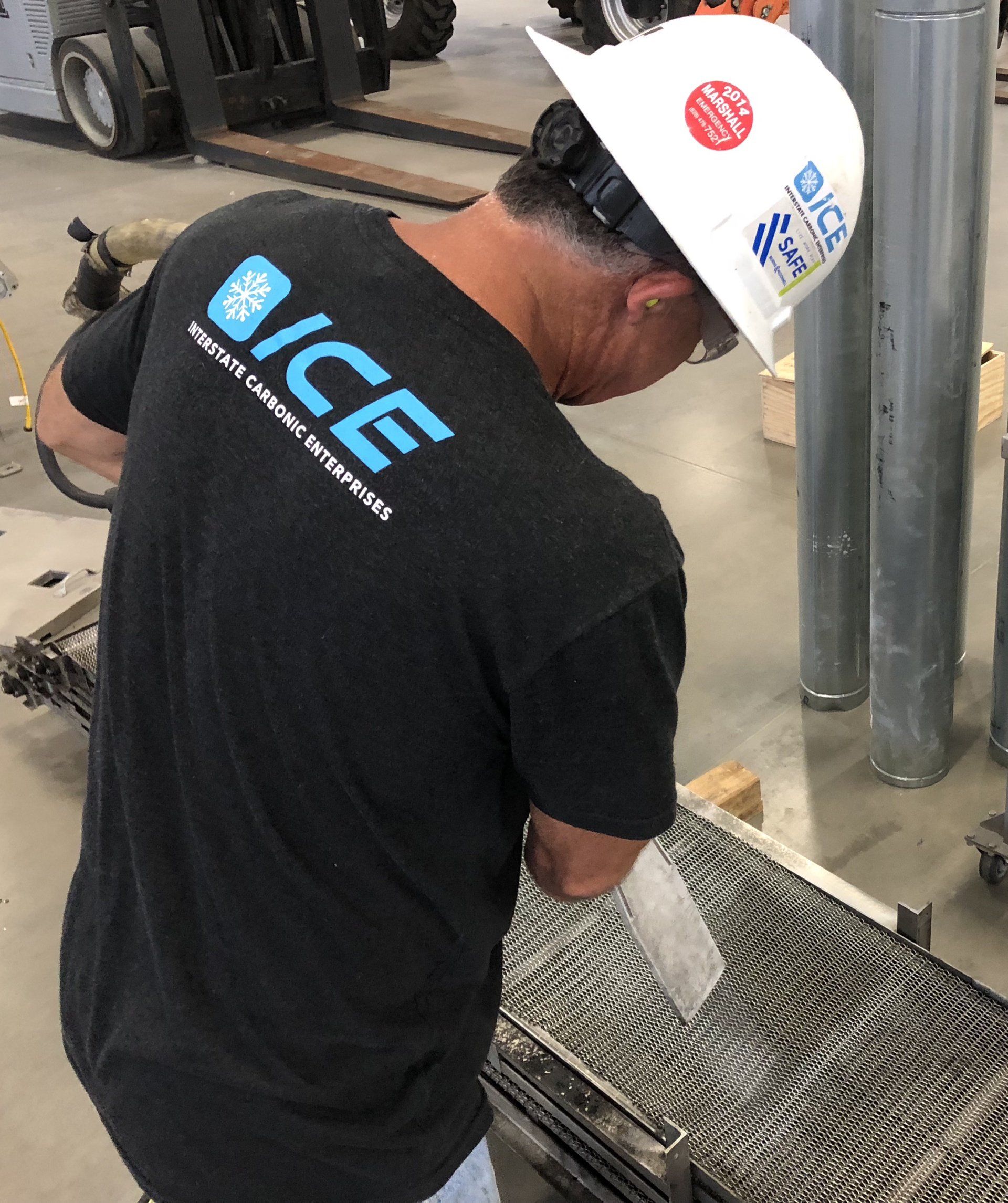 A man wearing a hard hat and a shirt that says ice