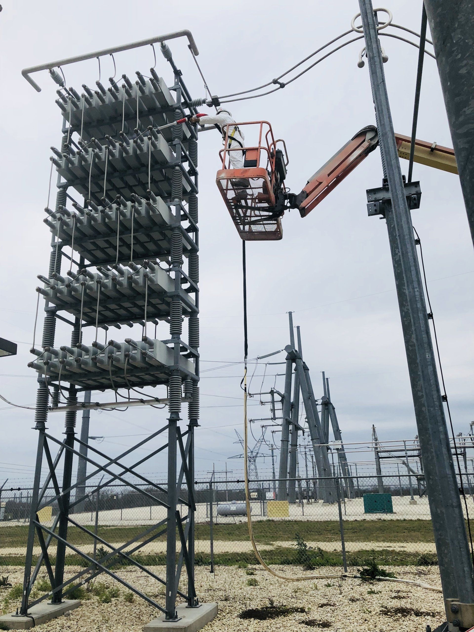 A man in a lift is working on a power tower