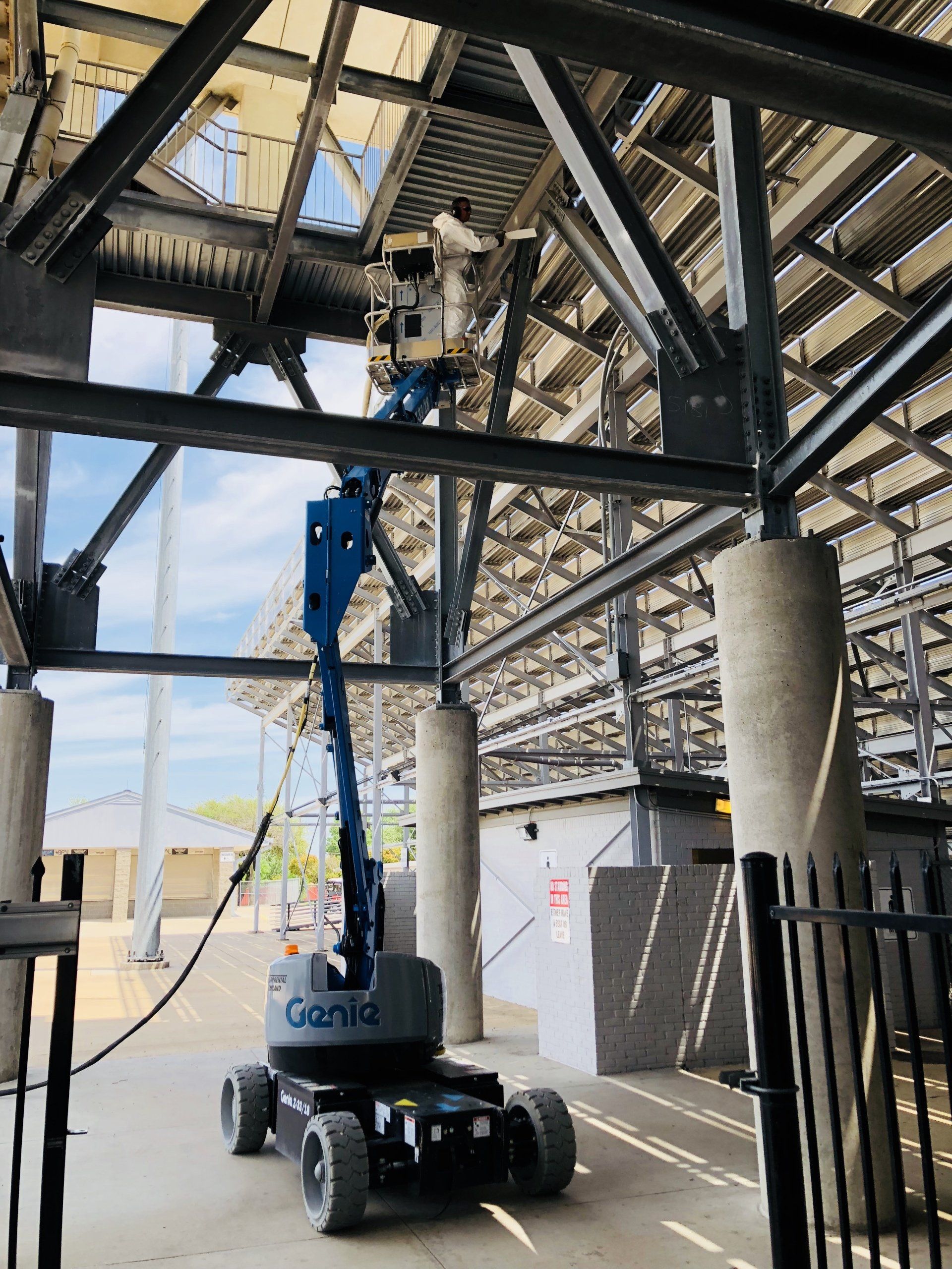 A crane is sitting under a roof of a building.