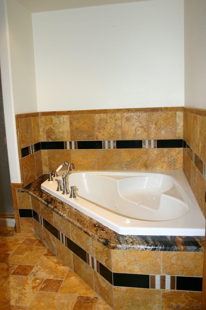 Woman in straw hat smiles, holding wine glass near a lake.
