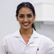 A woman in a lab coat is smiling for the camera