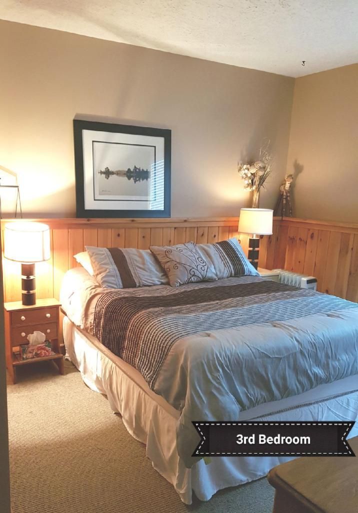 A bedroom with a king size bed and a picture on the wall.