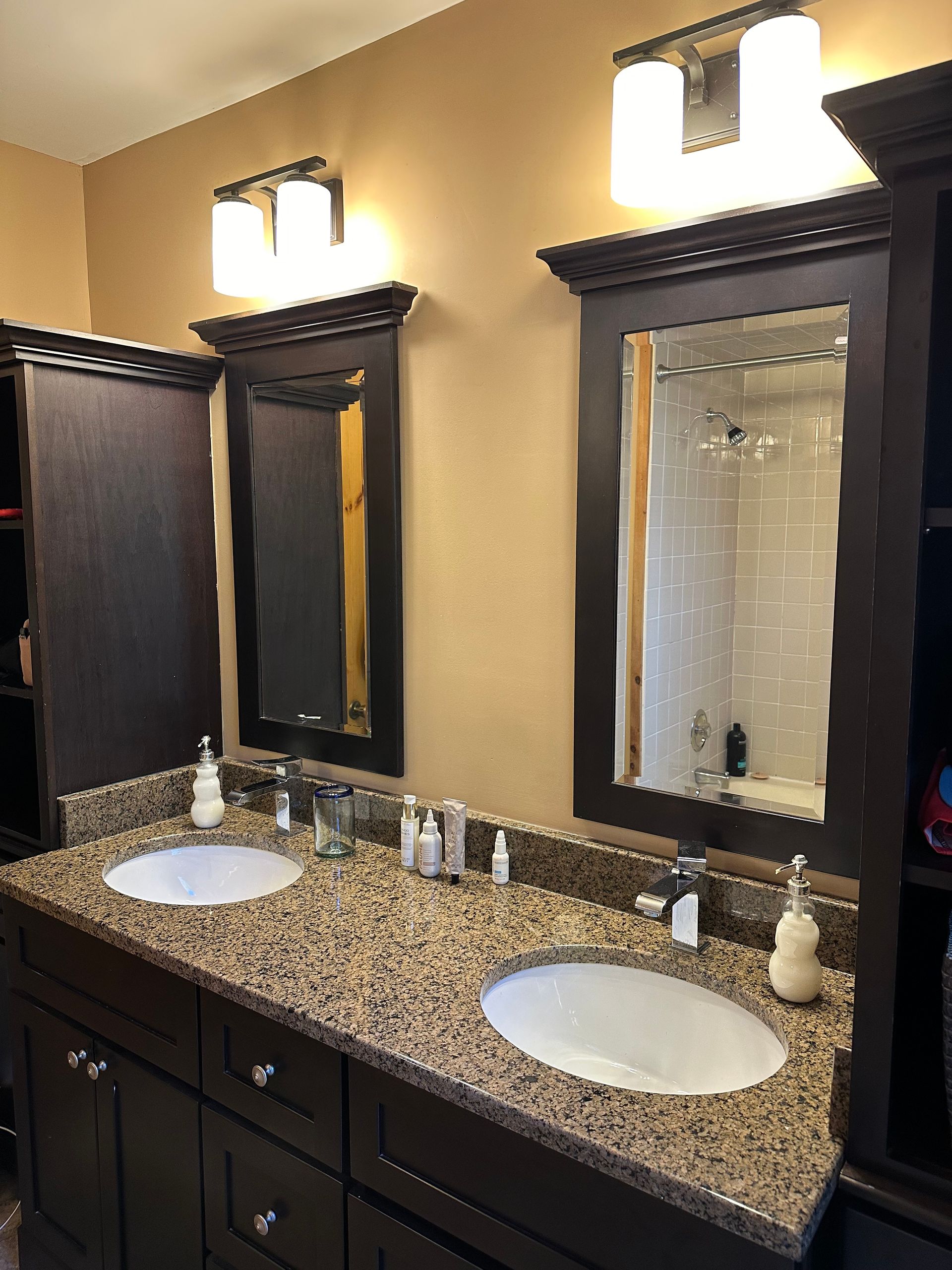 A bathroom with two sinks and two mirrors.