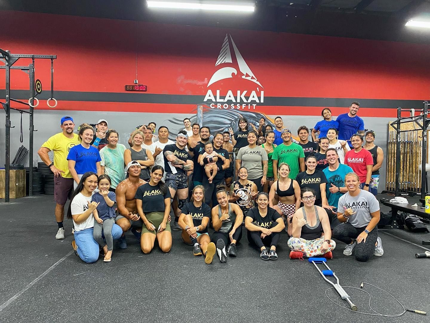 A group of people are posing for a picture in a gym.