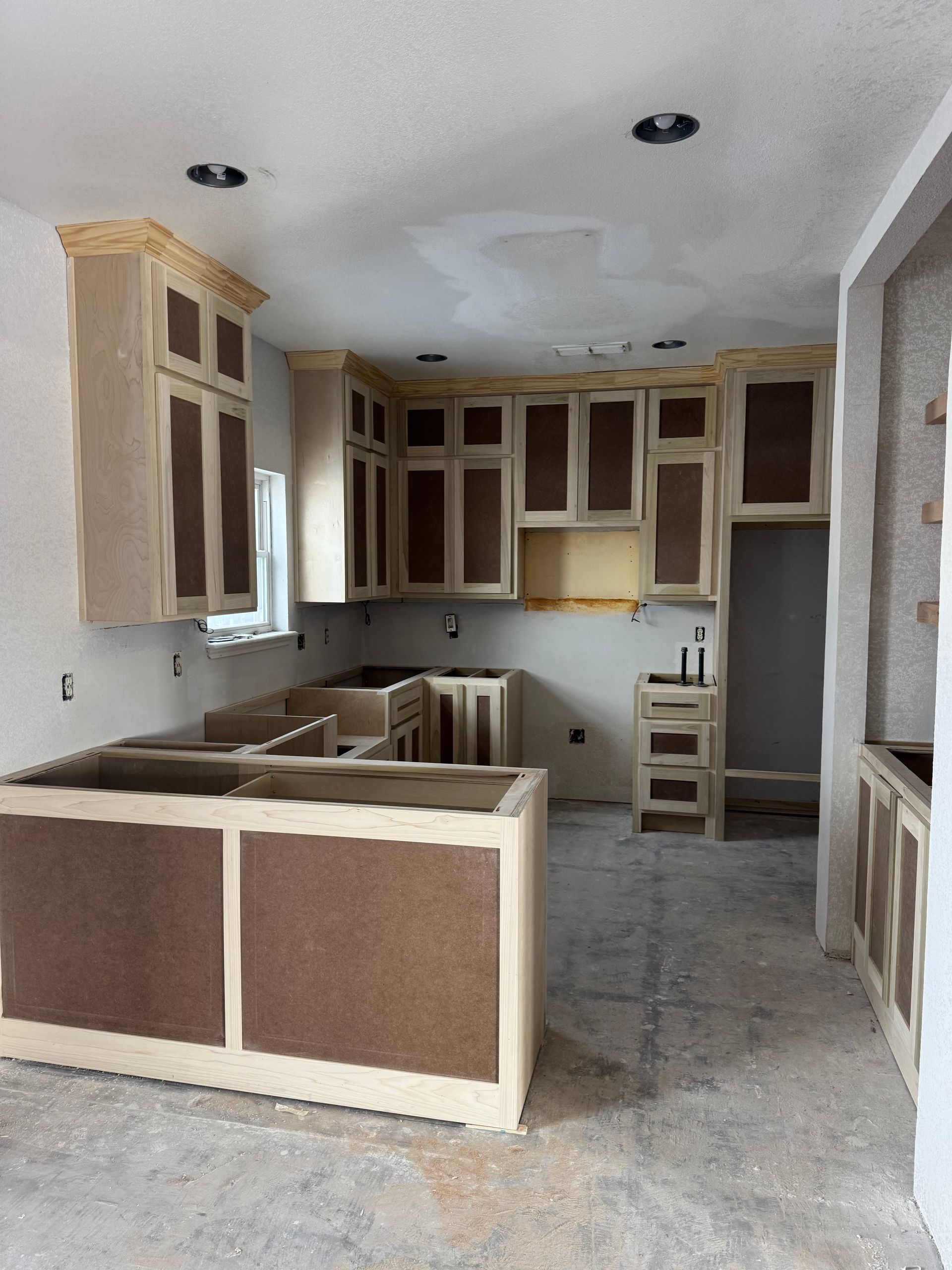 A kitchen that is being remodeled with wooden cabinets