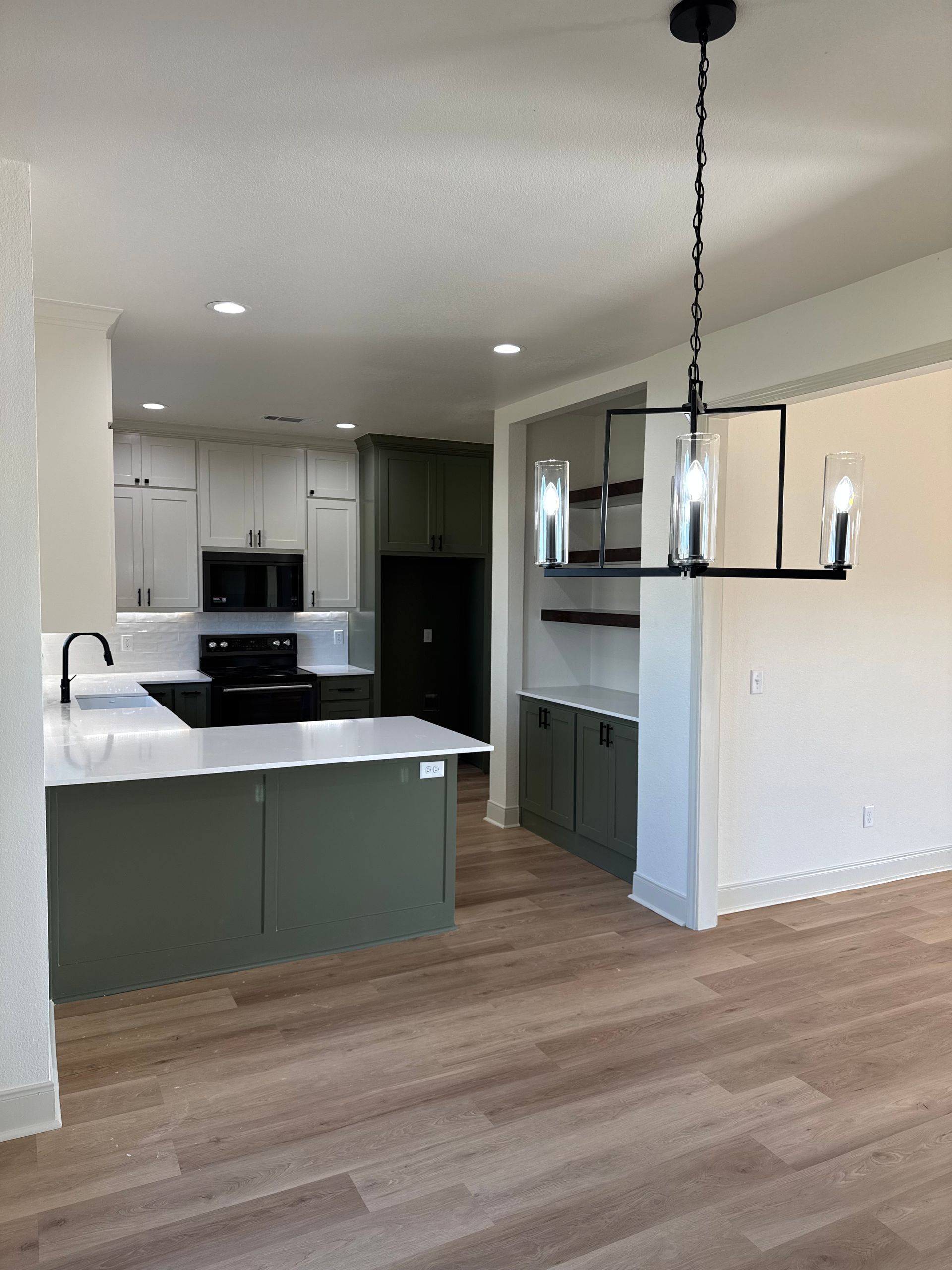 An empty kitchen with a chandelier hanging from the ceiling