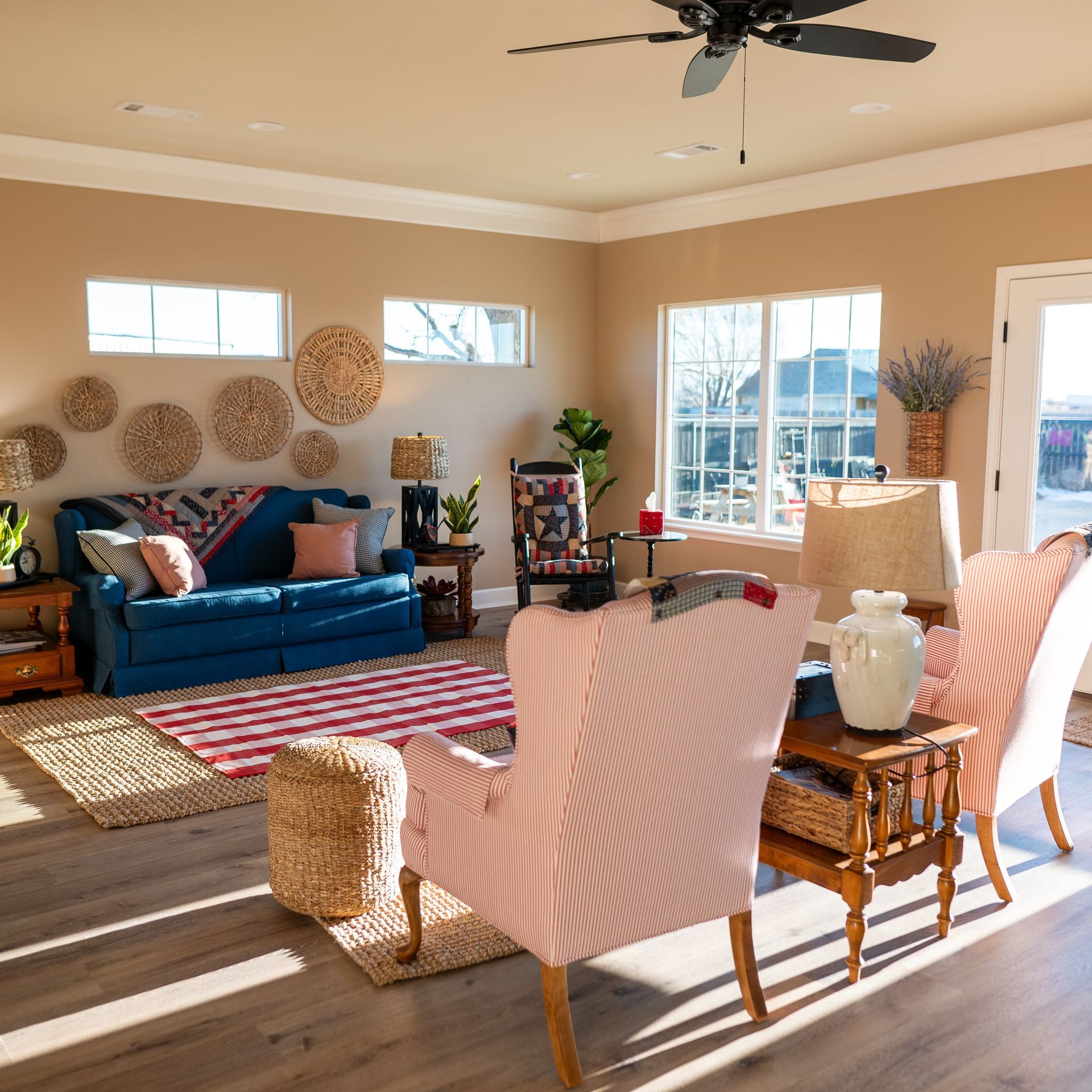 A living room with a blue couch and pink chairs