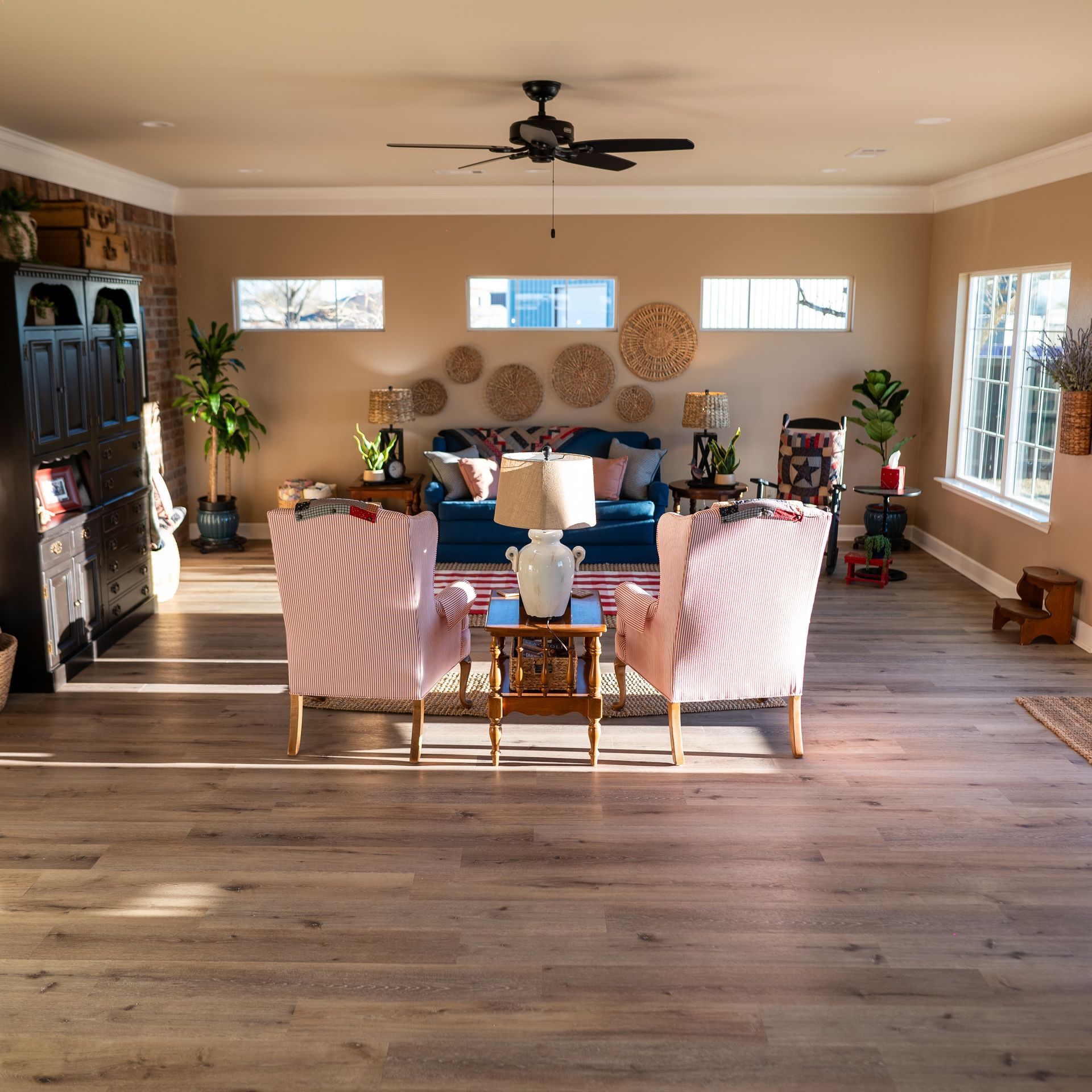 A living room with a blue couch and pink chairs