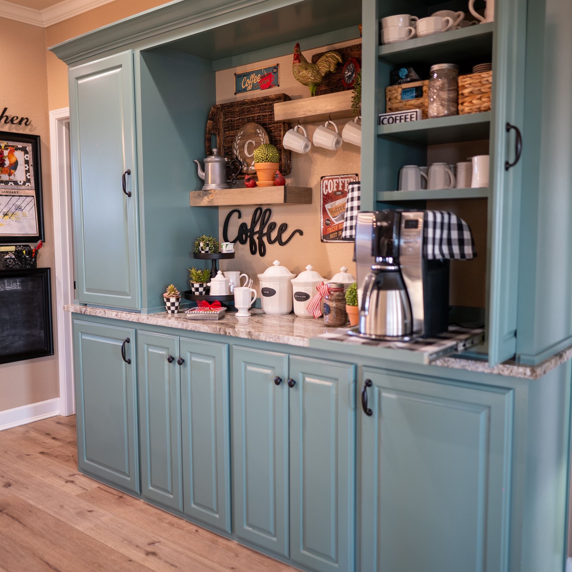 A kitchen with blue cabinets and a coffee sign on the wall