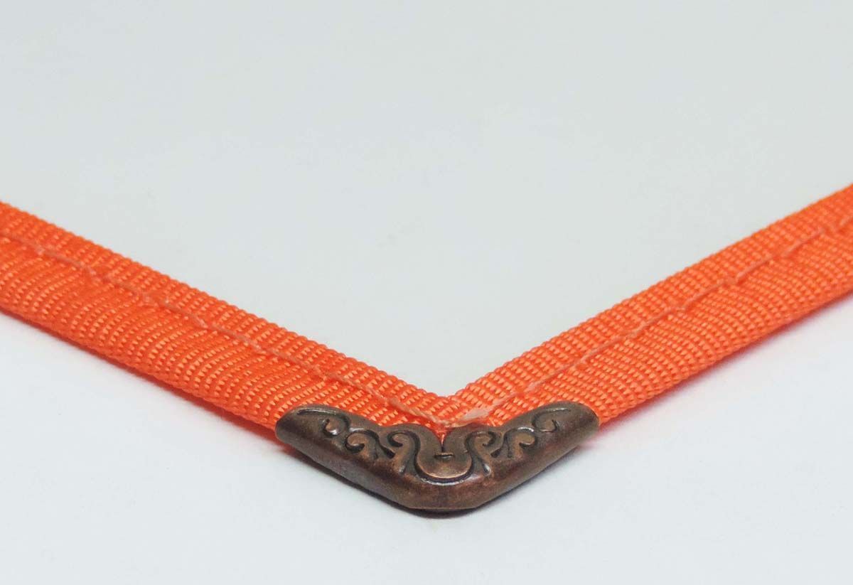 a close up of an orange ribbon with a metal corner