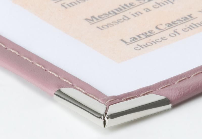 a close up of a pink menu with a silver corner