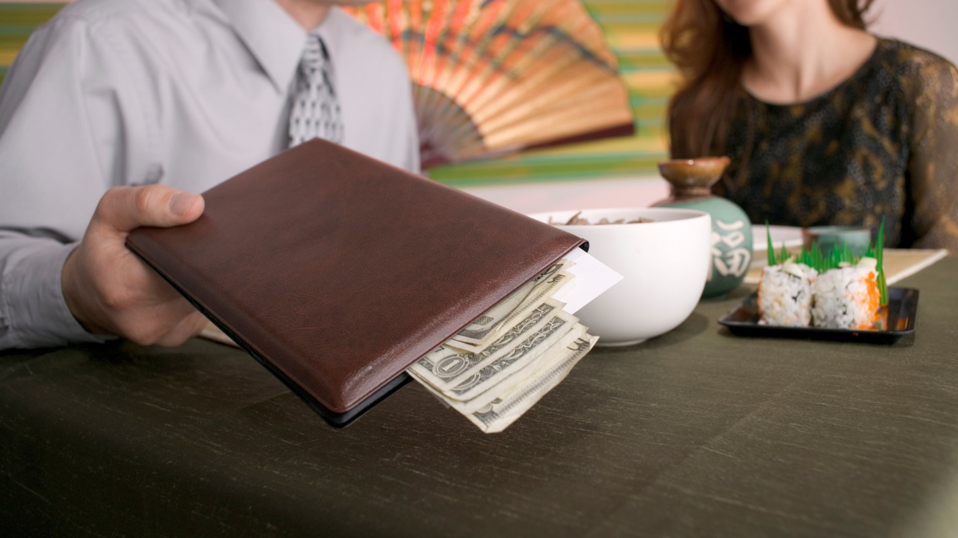 a man is holding a check presenter with cash