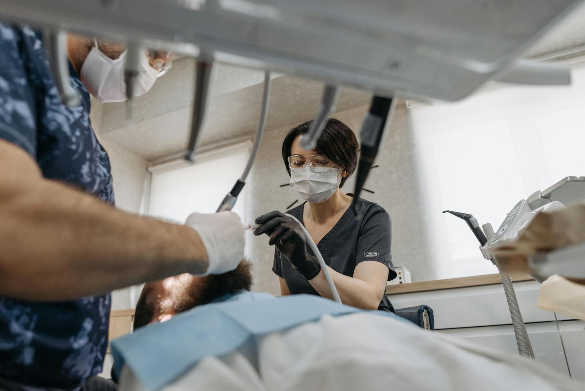 A dentist is examining a patient 's teeth in a dental office.