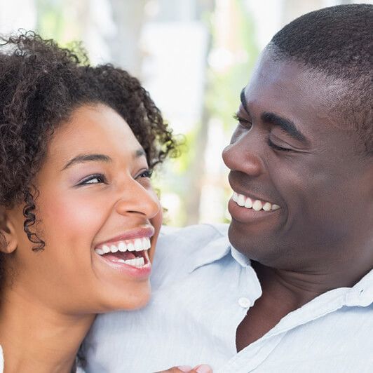 a man and a woman are laughing together and looking at each other