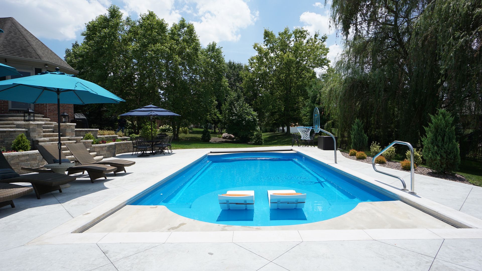 A large swimming pool surrounded by chairs and umbrellas