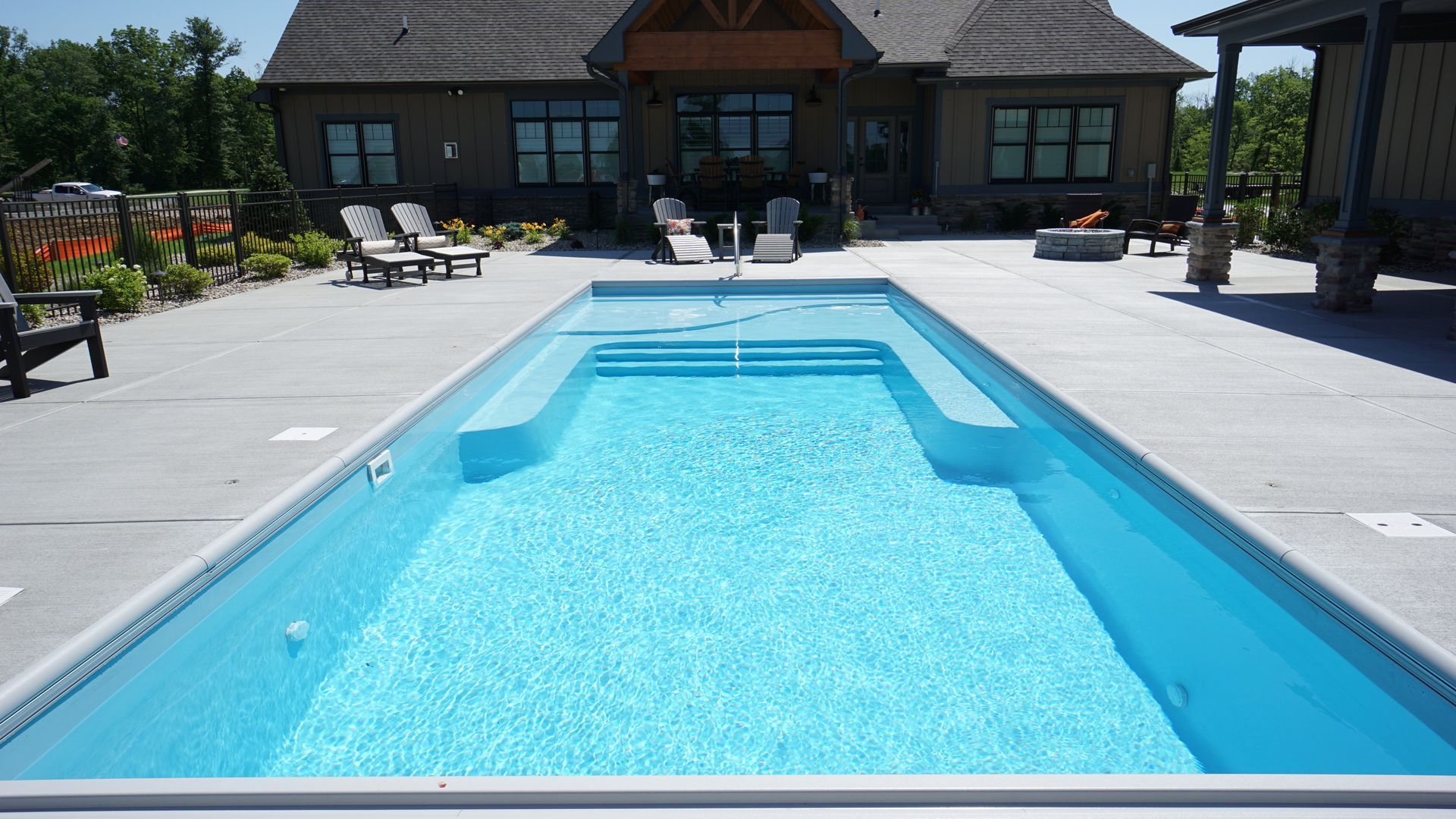 A large swimming pool in front of a house