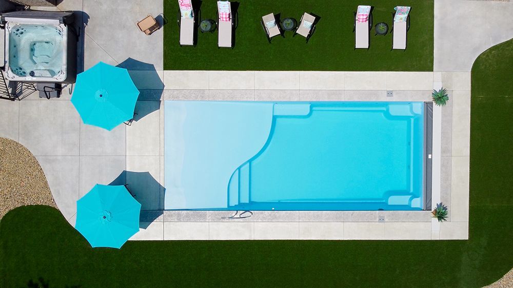 An aerial view of a large swimming pool surrounded by chairs and umbrellas.