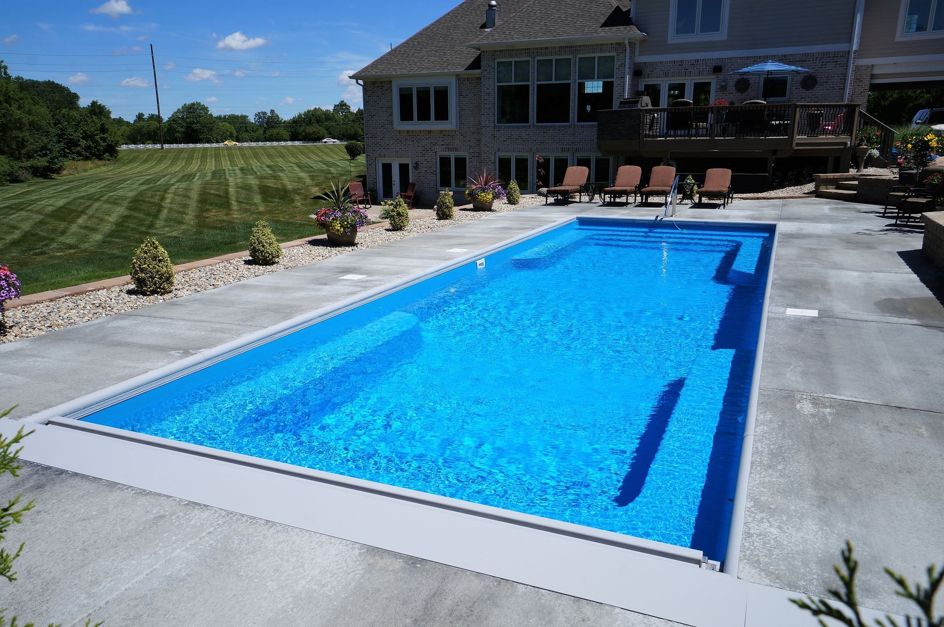 A large swimming pool in front of a large house