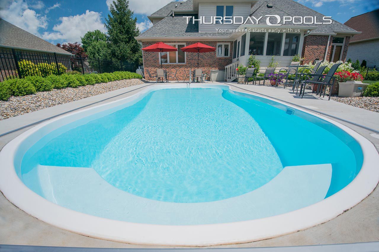 A large swimming pool in front of a house that says thursday pools