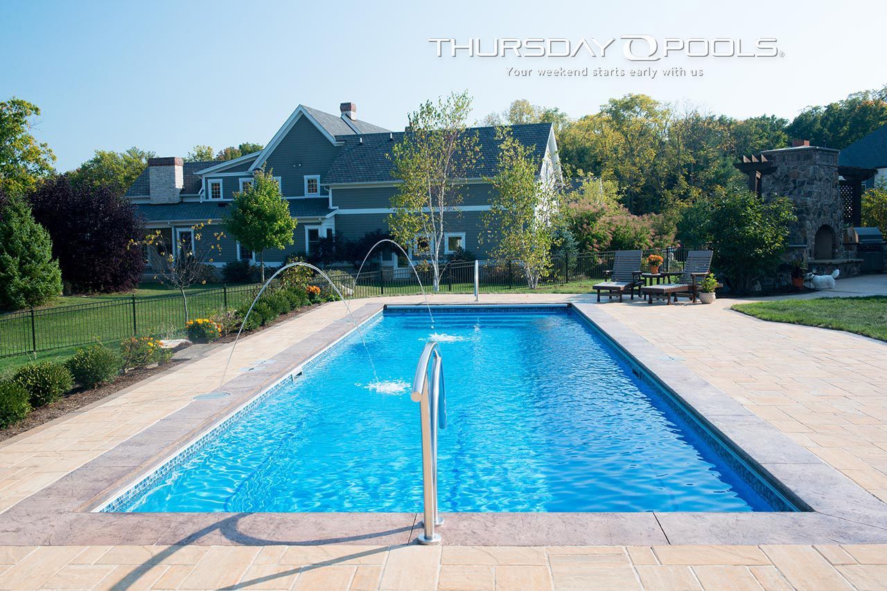 A large swimming pool in front of a large house