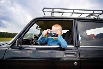 Child Taking Photograph out of Truck Window