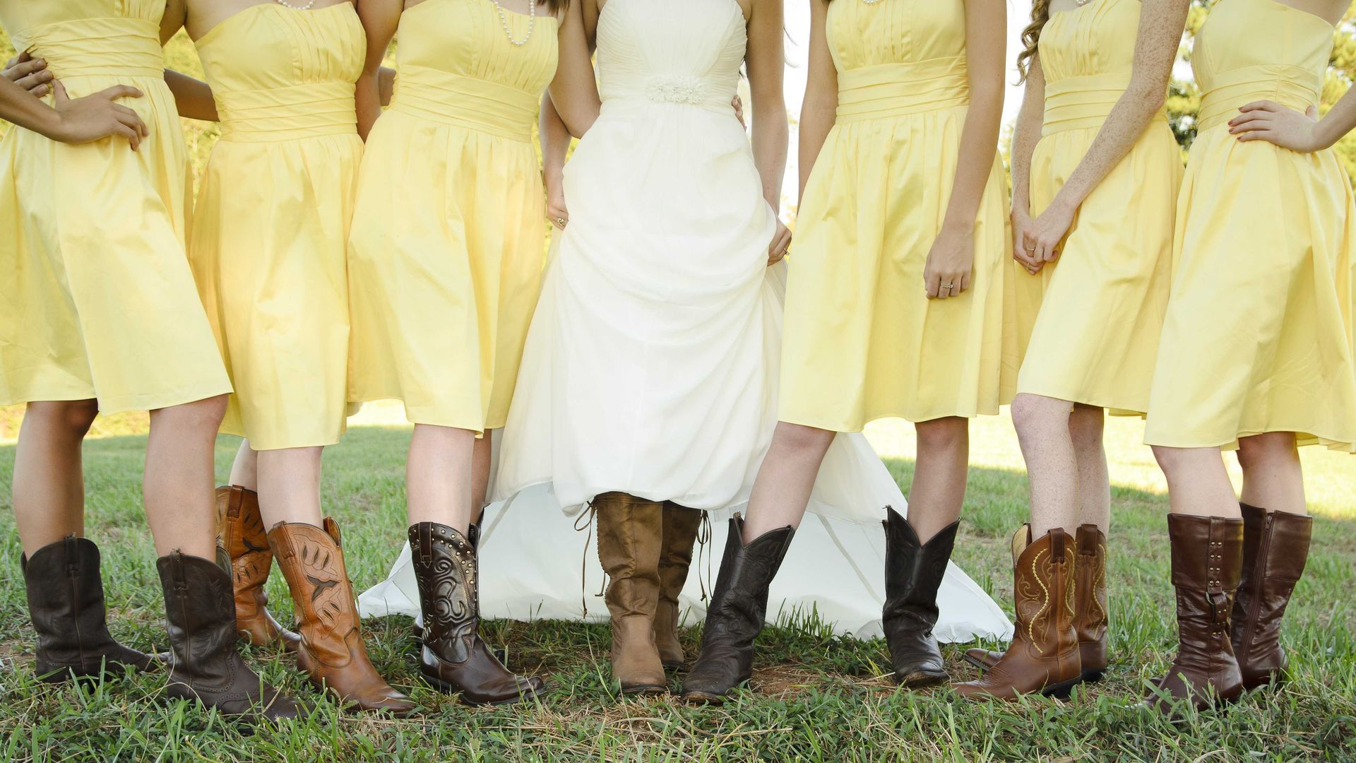 A bridal party in Texas showing off their cowboy boots for photo