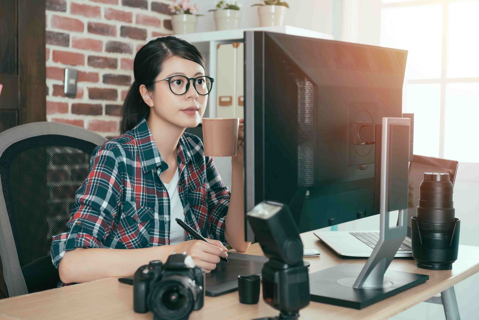 A woman photographer working on a desktop computer