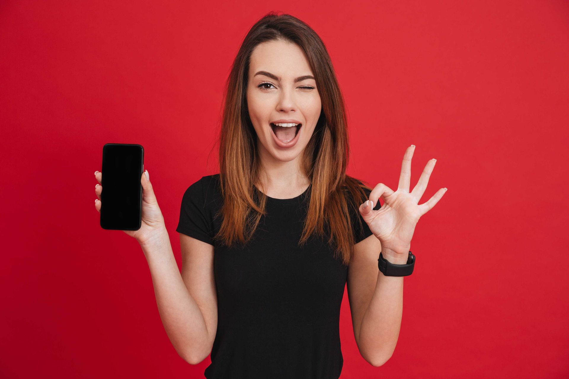 A profressional photograph with red background of business woman holding a smartphone