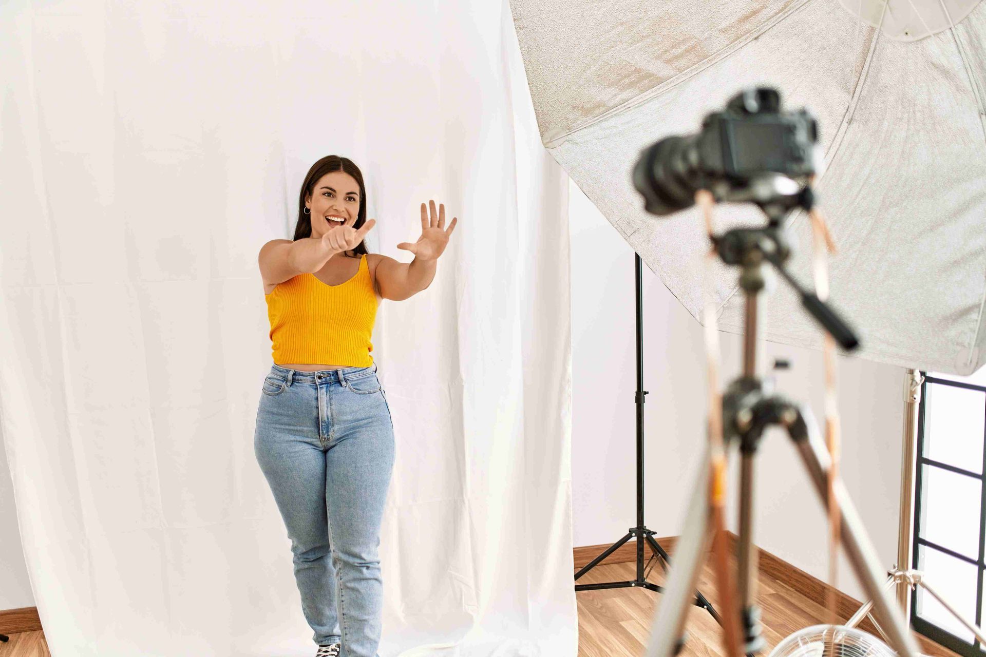 A woman doing a photoshoot in yellow shirt and jeans