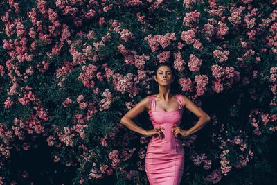 Woman posing with pink flower background