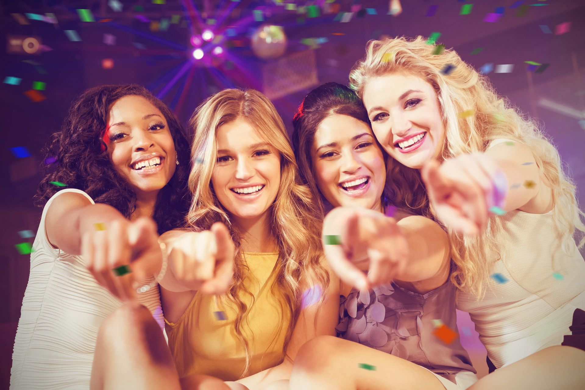 Women pointing toward camera at event