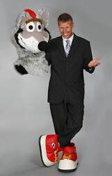 A man in a suit is standing next to a stuffed animal.