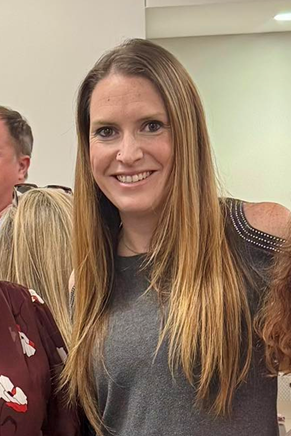 A man with a beard is wearing a suit and smiling for the camera.