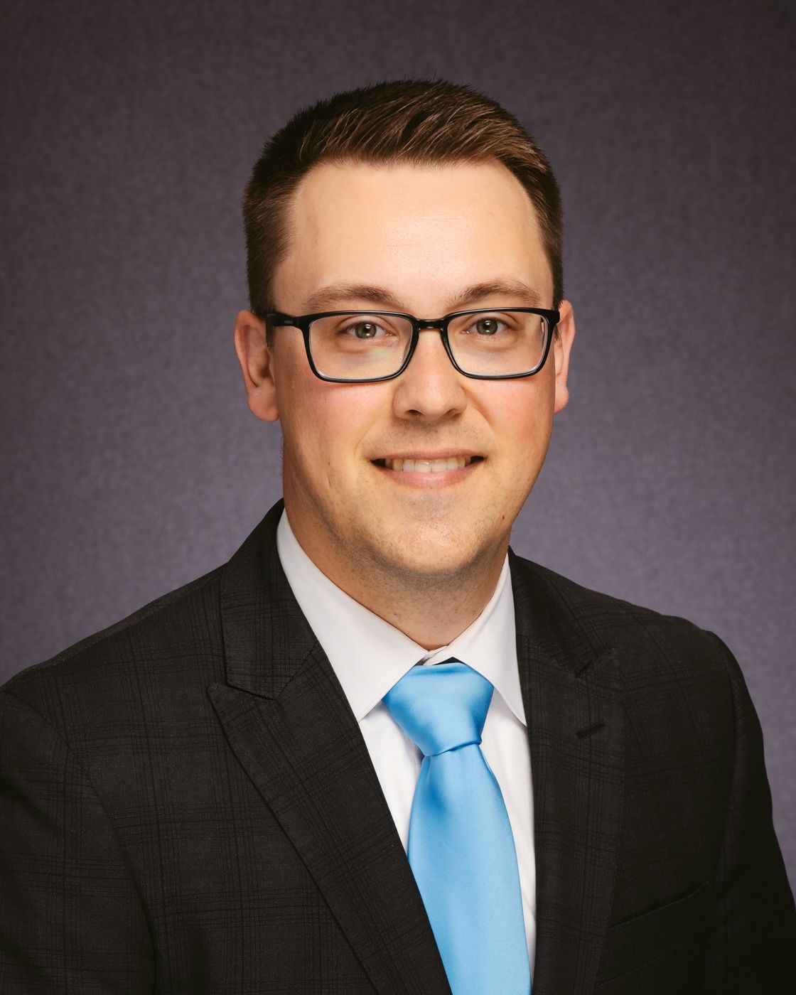 A man in a suit and tie is smiling for the camera.