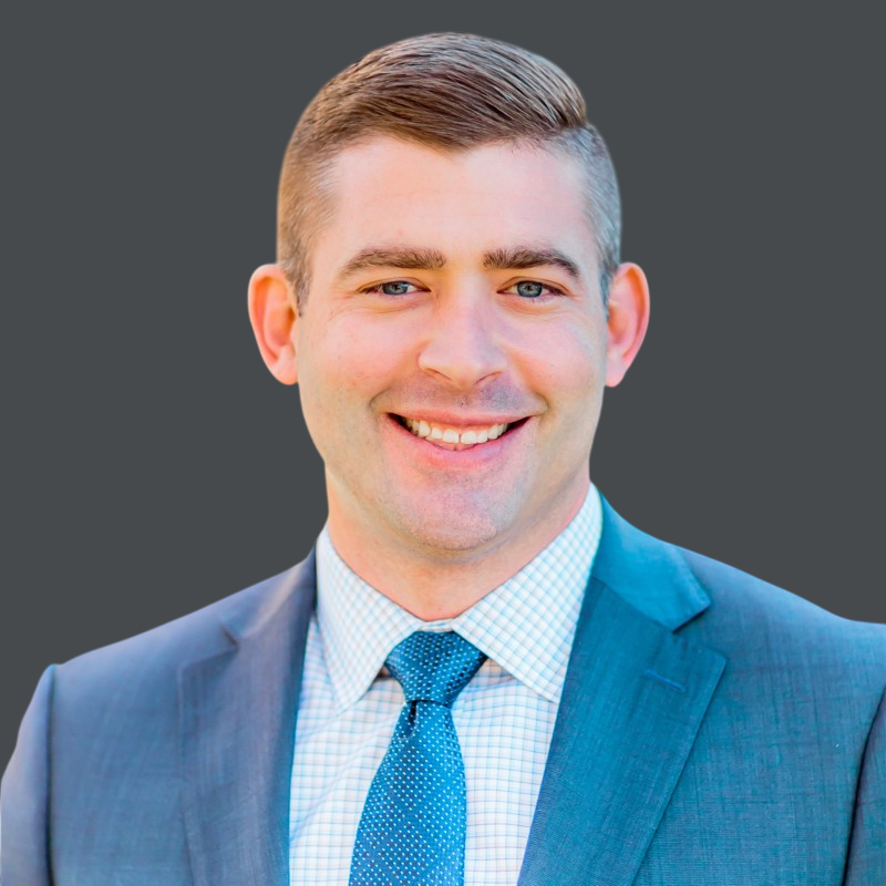 A man in a suit and tie is smiling for the camera.